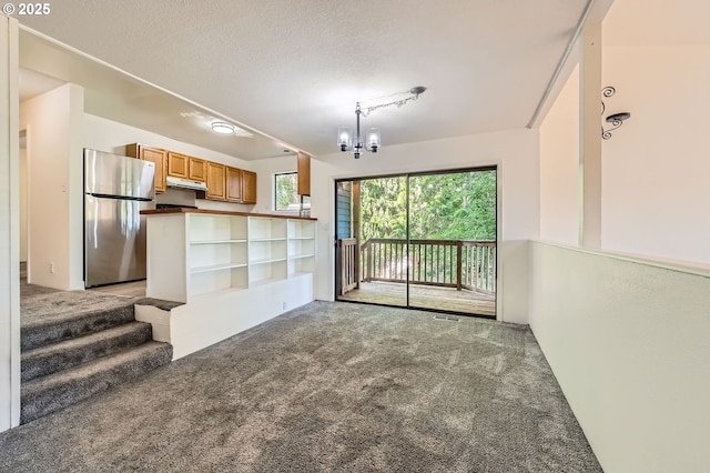 12140 SE Henderson Dr, Portland, OR 97266 - unfurnished living room with light carpet, a chandelier, and a textured ceiling