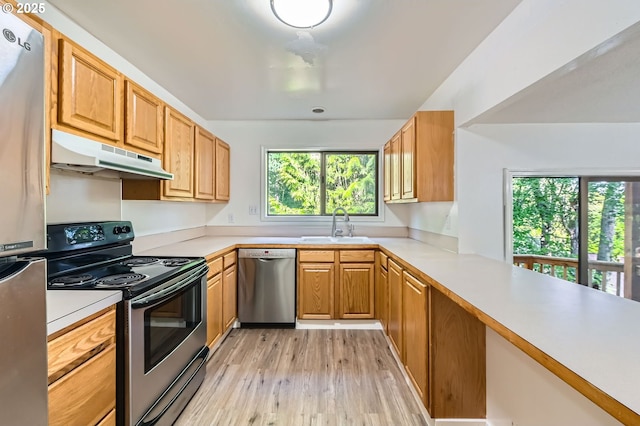12140 SE Henderson Dr, Portland, OR 97266 - kitchen with appliances with stainless steel finishes, under cabinet range hood, light wood-style floors, and light countertops