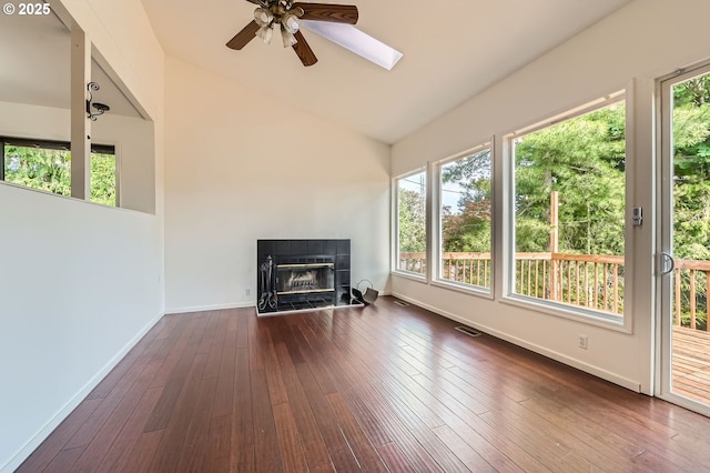 12140 SE Henderson Dr, Portland, OR 97266 - unfurnished living room with a tiled fireplace, plenty of natural light, ceiling fan, dark wood finished floors, and high vaulted ceiling