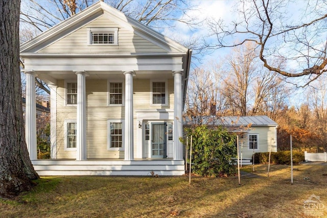 greek revival inspired property with a porch and a front lawn