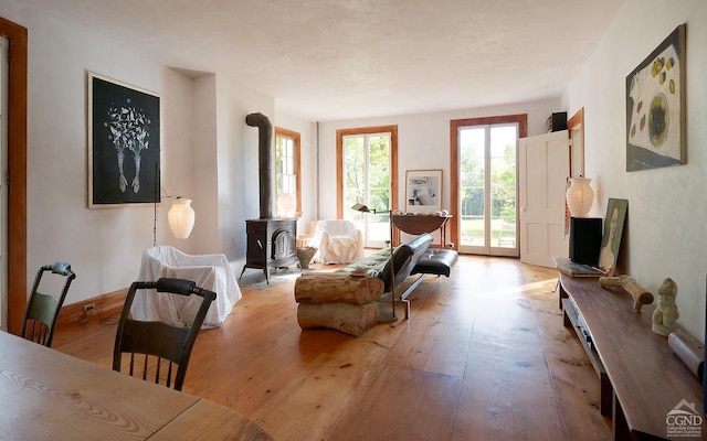 sitting room featuring light wood-type flooring and a wood stove