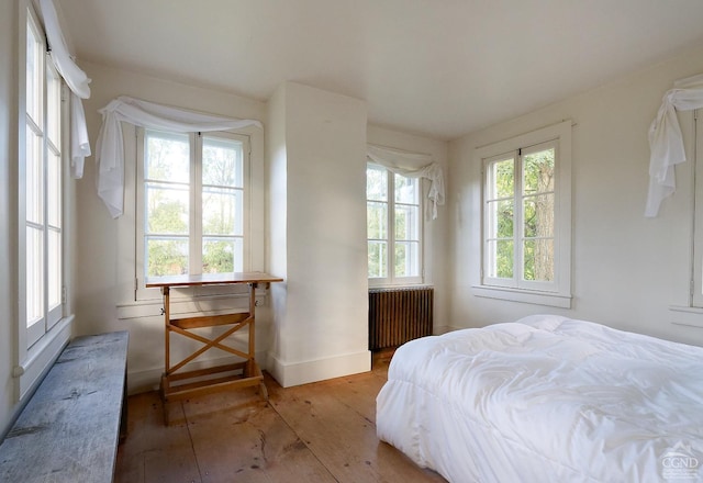 bedroom featuring light wood-type flooring and radiator