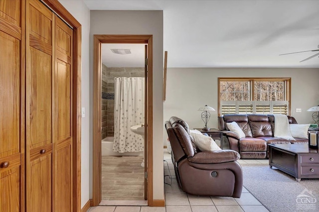 living room with light tile patterned flooring, visible vents, and ceiling fan