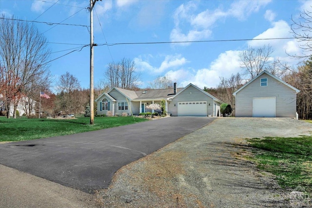single story home featuring a detached garage, driveway, and a front lawn