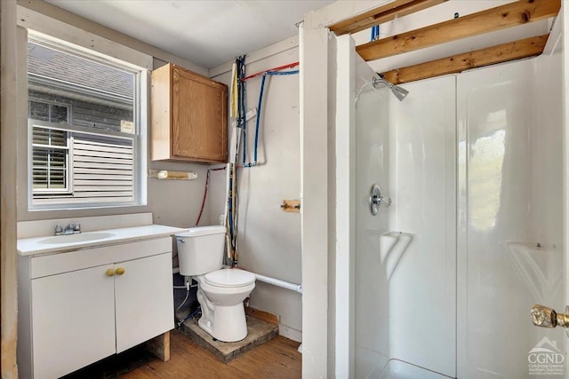 full bath featuring a stall shower, toilet, wood finished floors, and vanity