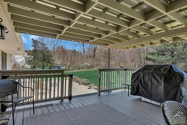 wooden terrace featuring area for grilling and a yard