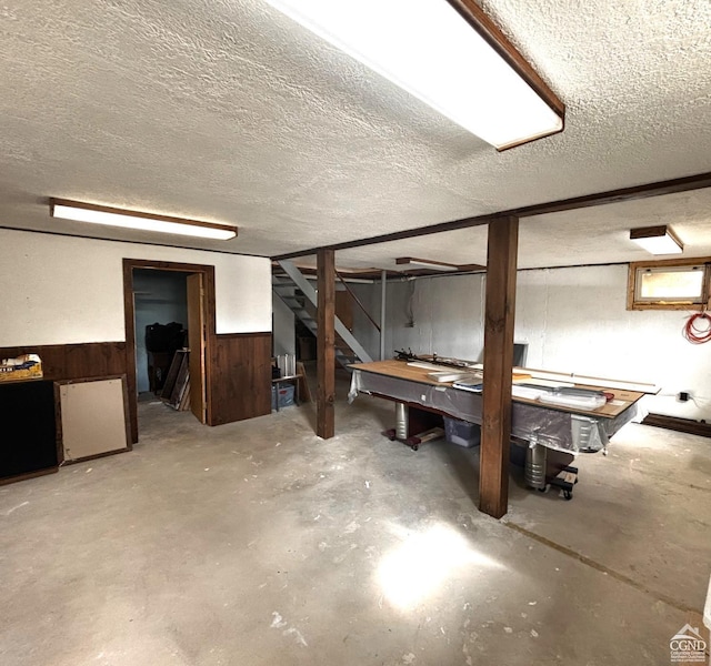 basement with wood walls and a textured ceiling