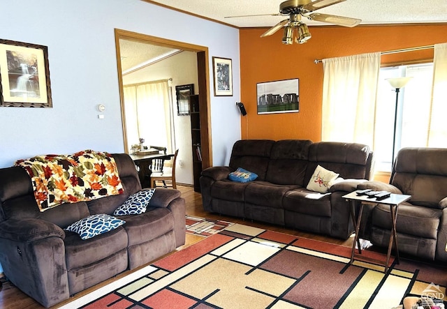 living room featuring hardwood / wood-style floors, lofted ceiling, ceiling fan, ornamental molding, and a textured ceiling