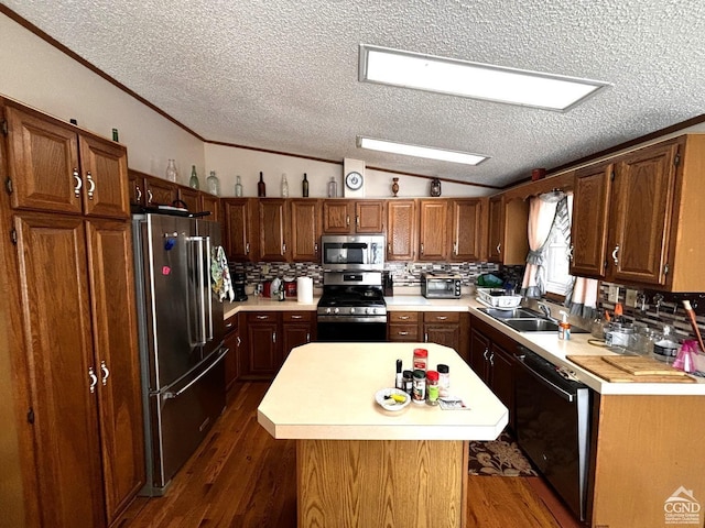 kitchen featuring a kitchen island, dark hardwood / wood-style flooring, a textured ceiling, and appliances with stainless steel finishes