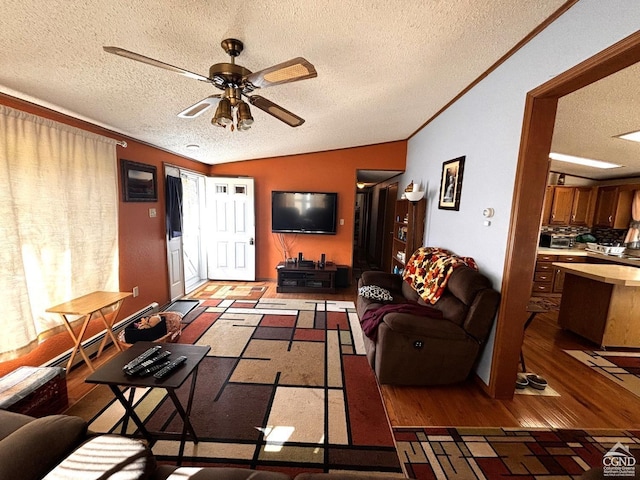 living room with ornamental molding, a textured ceiling, vaulted ceiling, ceiling fan, and wood-type flooring