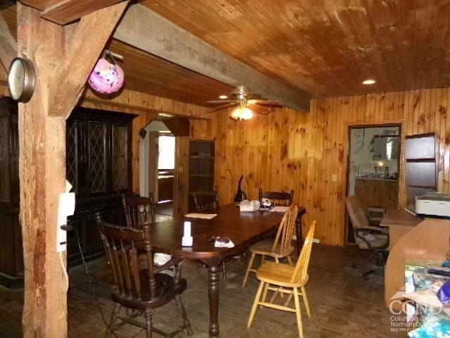 dining space featuring wooden ceiling, beamed ceiling, and wood walls