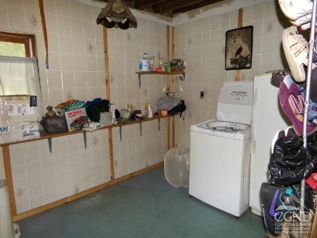 laundry area with washer / dryer and tile walls