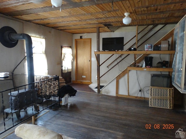 basement with dark wood-type flooring, wooden ceiling, and a wood stove