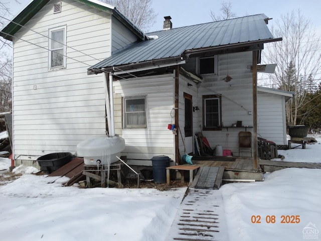 view of snow covered rear of property