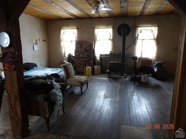 bedroom featuring dark hardwood / wood-style floors, a wood stove, and wood ceiling