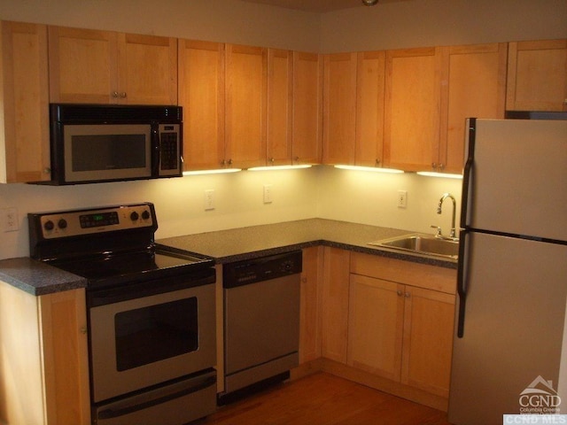 kitchen with sink, hardwood / wood-style floors, appliances with stainless steel finishes, and light brown cabinets