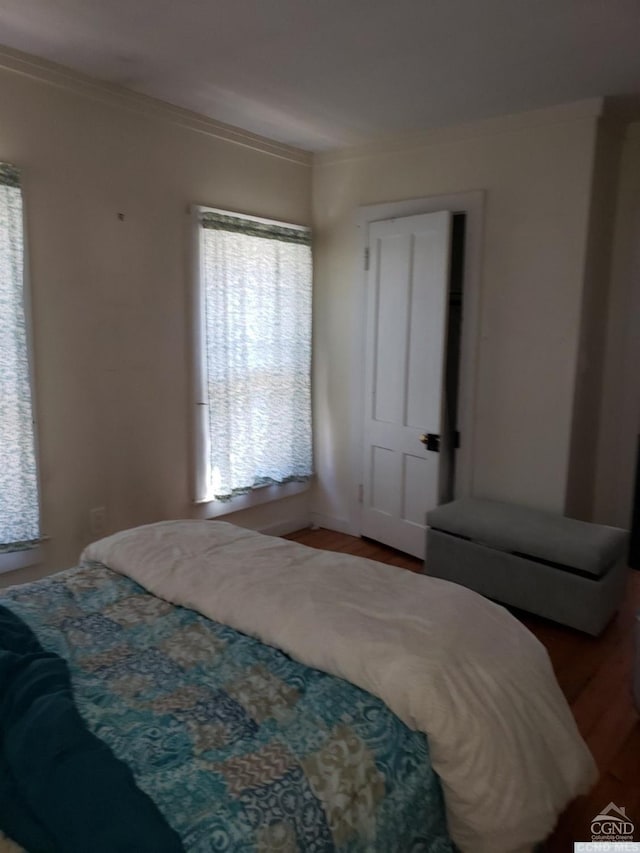 bedroom with wood-type flooring and ornamental molding