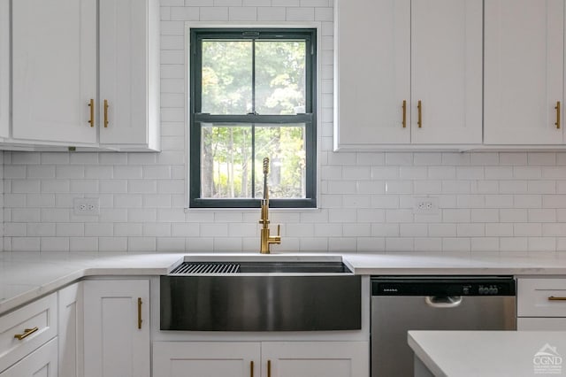 kitchen featuring dishwasher, sink, light stone counters, decorative backsplash, and white cabinets