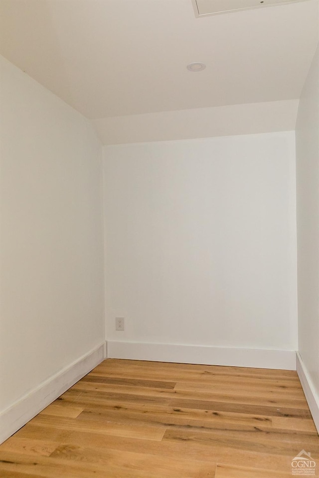 empty room featuring lofted ceiling and wood-type flooring