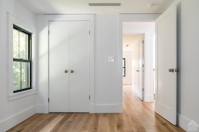 unfurnished bedroom with a closet and light hardwood / wood-style flooring