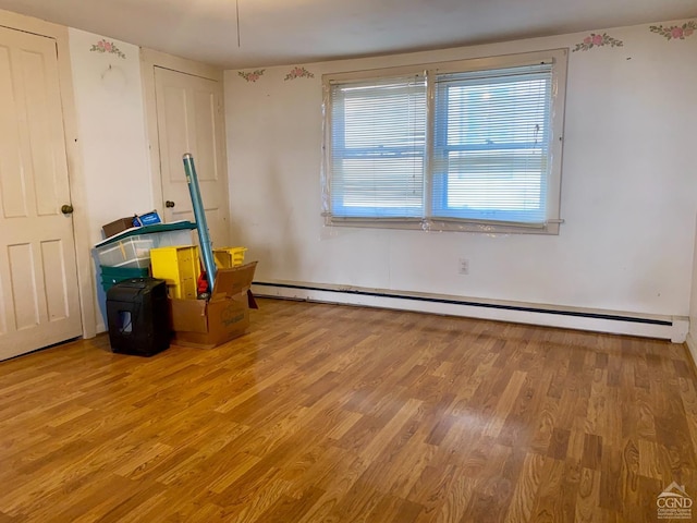 miscellaneous room with hardwood / wood-style flooring and a baseboard heating unit