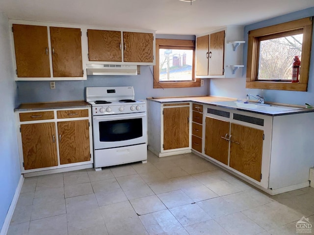 kitchen with white electric range oven, a healthy amount of sunlight, and light tile patterned floors