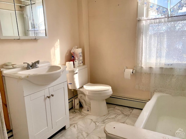 bathroom with a bath, vanity, a baseboard radiator, and toilet