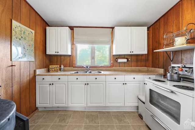 kitchen with sink, white electric range oven, light tile patterned floors, wood walls, and white cabinets