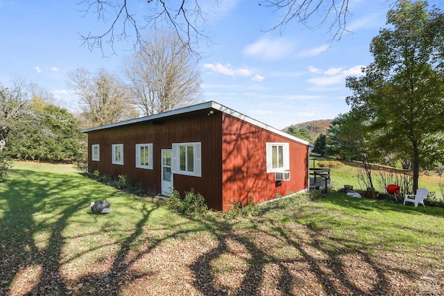 view of side of home featuring a yard and an outdoor structure