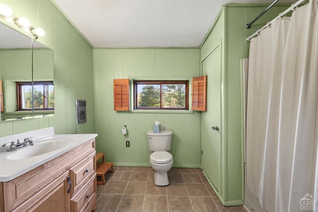 bathroom featuring a shower with shower curtain, vanity, toilet, and a wealth of natural light