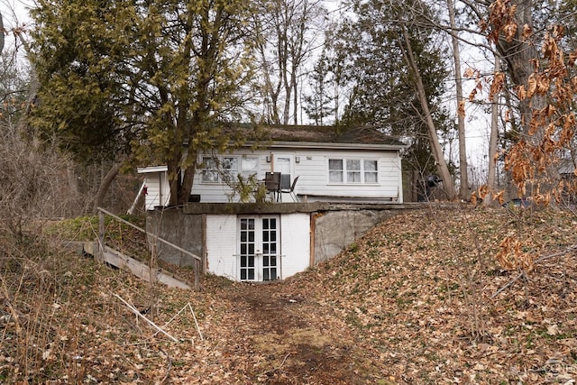 back of property featuring brick siding and french doors