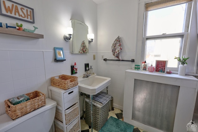 bathroom with tile walls and toilet