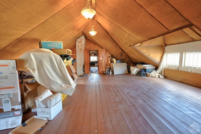 bonus room with wooden walls, lofted ceiling, and hardwood / wood-style flooring