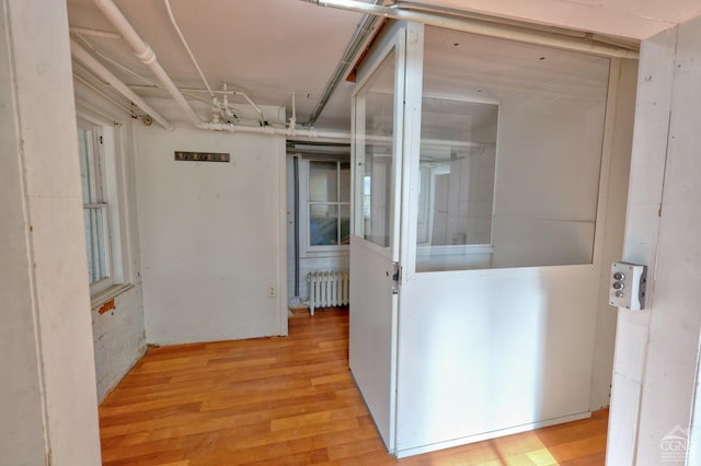 hall with light hardwood / wood-style floors and radiator