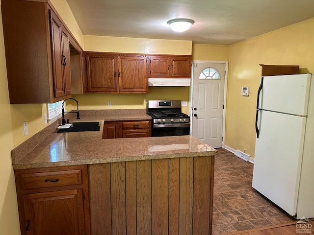 kitchen featuring sink, white refrigerator, plenty of natural light, and stainless steel gas range