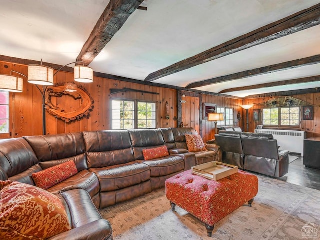 living area featuring wood finished floors, beam ceiling, wood walls, and radiator heating unit