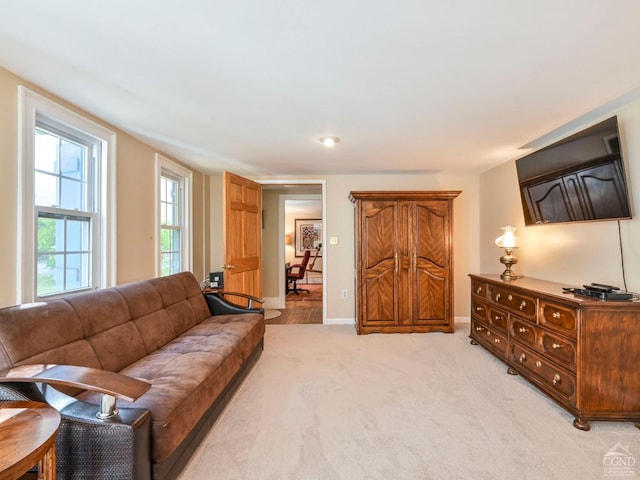 living area with light carpet and baseboards