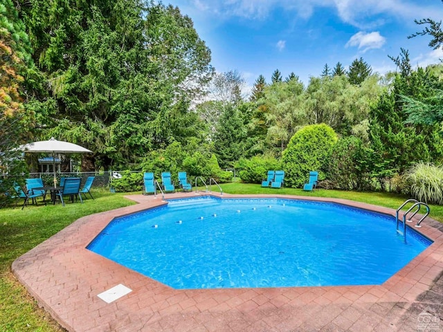 view of swimming pool with a lawn, fence, a patio, and a fenced in pool