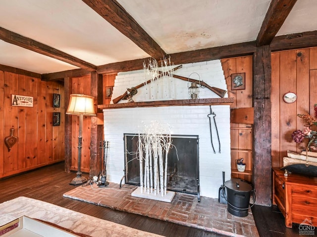 unfurnished living room with a brick fireplace, wood finished floors, beamed ceiling, and wood walls