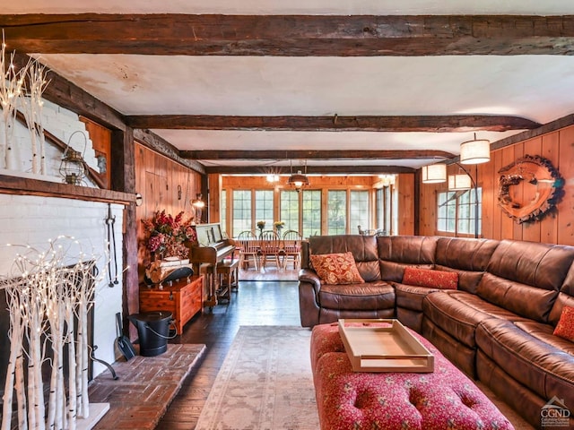 living area with beam ceiling, wooden walls, and dark wood-style flooring