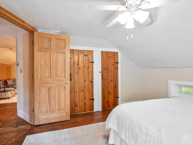 bedroom with a ceiling fan, vaulted ceiling, and wood finished floors