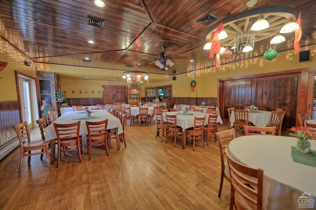 dining room with wood ceiling, ceiling fan, a towering ceiling, and wood-type flooring