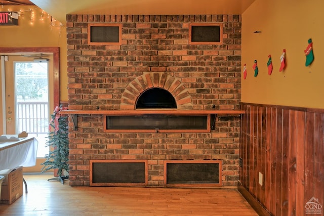 living room with light hardwood / wood-style flooring and wooden walls