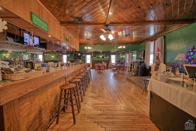 bar featuring ceiling fan, beam ceiling, and wooden ceiling