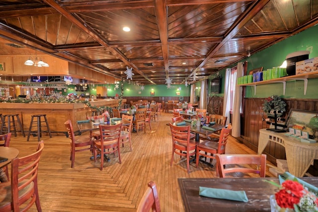 dining space with beamed ceiling, wood ceiling, and light hardwood / wood-style floors