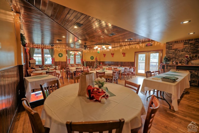 dining area with hardwood / wood-style floors, high vaulted ceiling, a wealth of natural light, and wood ceiling