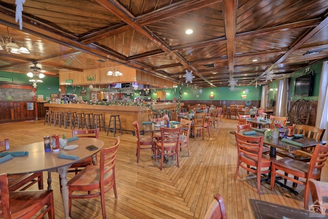 dining space with beamed ceiling, light wood-type flooring, wood ceiling, and coffered ceiling