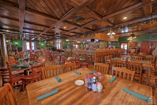 dining space featuring a notable chandelier, a healthy amount of sunlight, wood ceiling, and beam ceiling