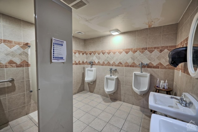 bathroom with tile patterned flooring, sink, tile walls, and a bidet