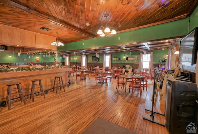 dining room with wood-type flooring, a notable chandelier, and wood ceiling